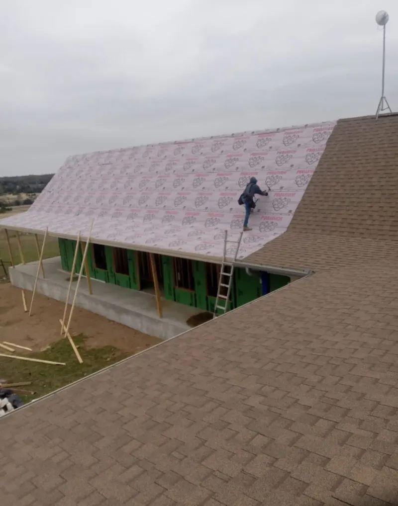 Worker preparing underlayment for a metal roof installation in Fallston